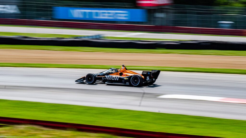 IndyCar speeding on track at Mid-Ohio Sports Car Course. Experience the thrill of motor racing.