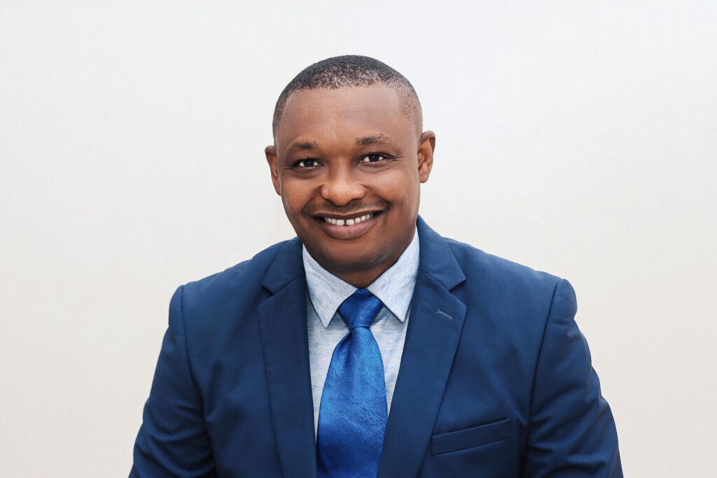 Elegant portrait of a man in a blue suit and tie, exuding confidence and style.