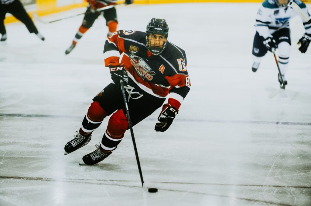 Dynamic action shot of a hockey player skating on an ice rink during a game.