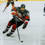 Dynamic action shot of a hockey player skating on an ice rink during a game.