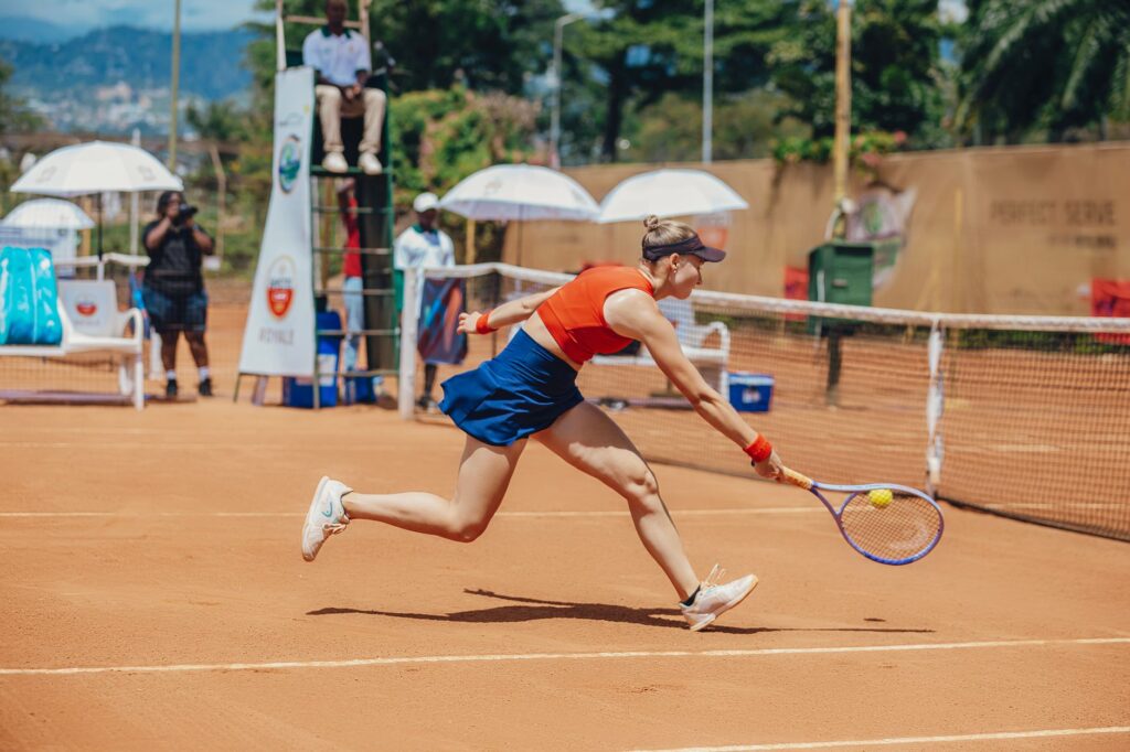 Dynamic tennis match on a clay court outdoors, showcasing athletic skill and intense competition.