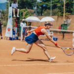 Dynamic tennis match on a clay court outdoors, showcasing athletic skill and intense competition.