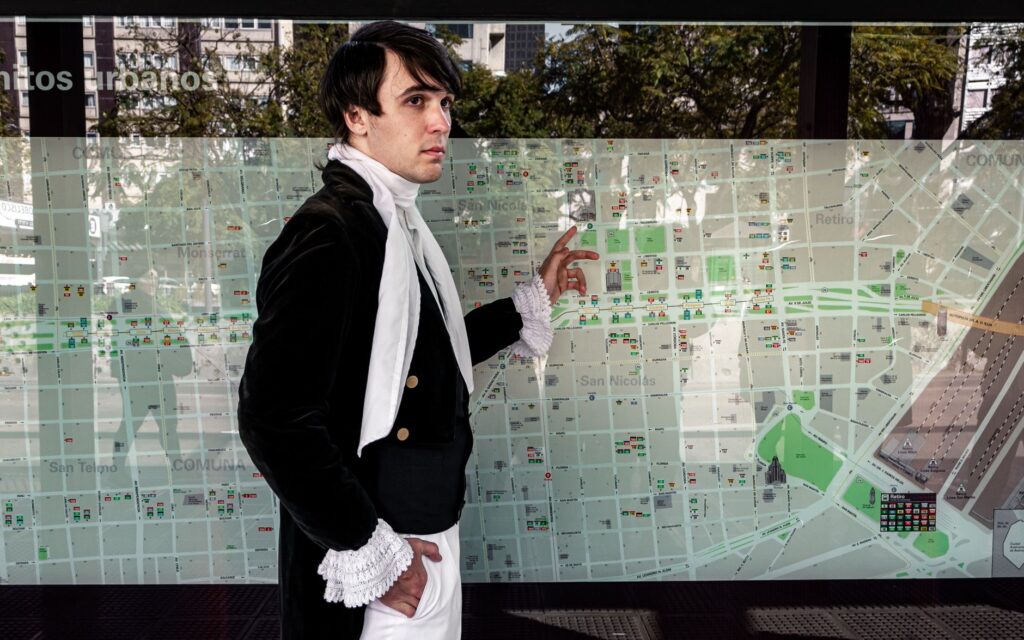 A man in historical attire studies a city map at an outdoor location in Buenos Aires.