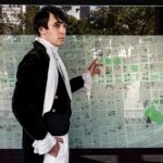 A man in historical attire studies a city map at an outdoor location in Buenos Aires.