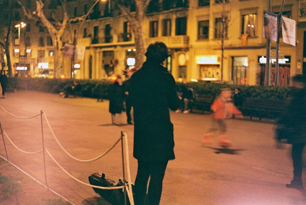 A street musician plays the violin on a bustling evening in Barcelona, Spain.