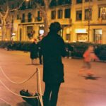 A street musician plays the violin on a bustling evening in Barcelona, Spain.