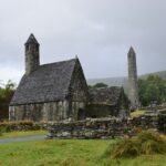 A serene view of the ancient St. Kevin's Church against an overcast sky in Glendalough, Ireland.