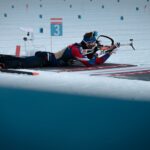 Biathlete competes in a snowy biathlon event, aiming with precision and focus.