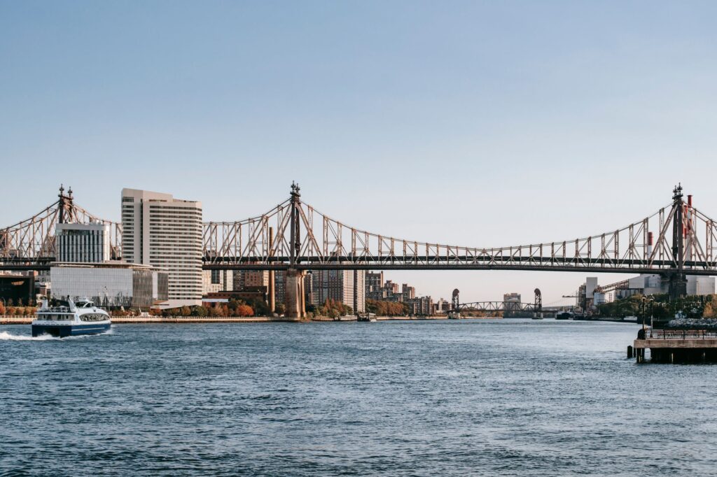 Famous cantilever Queensboro Bridge crossing East river placed in New York City under cloudless clue sky in daytime
