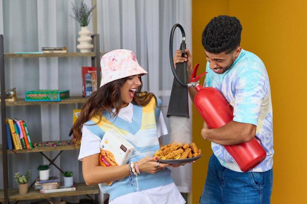 A fun moment indoors with friends enjoying snacks and a humorous twist using a fire extinguisher.