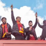 Fans celebrate with Liverpool FC players during a victory parade in Liverpool, England.