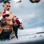 Focused boxer in action at outdoor match, showcasing strength and determination.
