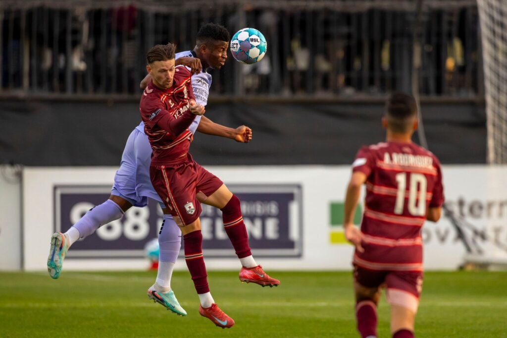 Players engage fiercely during a competitive soccer match, capturing a dynamic moment of athleticism.
