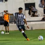 An intense moment as a soccer player executes a powerful kick on the field during a competitive match.