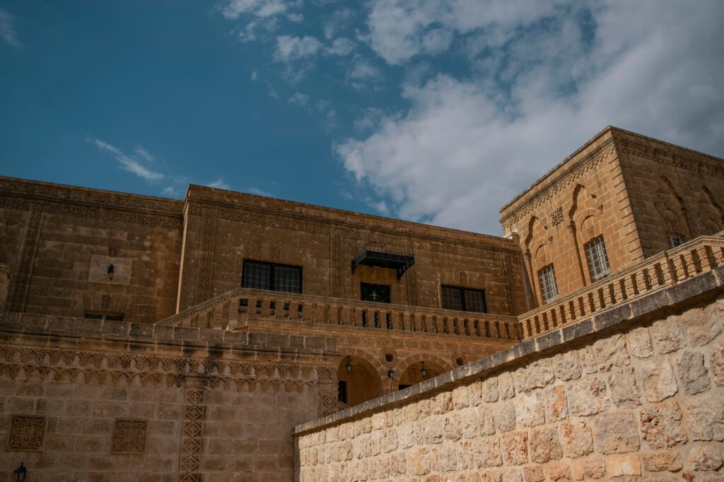 Beautiful historic stone building in Midyat, showcasing intricate designs and clear skies.