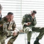 Veterans share a light moment during a group therapy session, indoors.