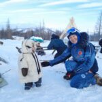 Family dressed in winter clothing, enjoying snow in Yamal-Nenets Autonomous Okrug, Russia.
