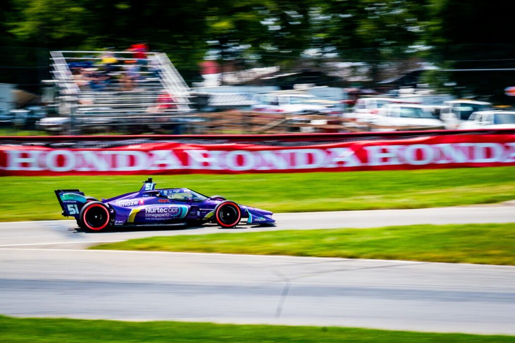 A thrilling IndyCar race car speeding through Mid-Ohio Sports Car Course in Lexington.