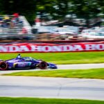 A thrilling IndyCar race car speeding through Mid-Ohio Sports Car Course in Lexington.