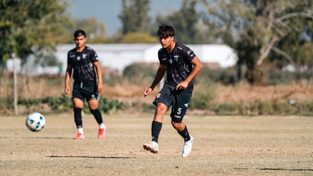 Dynamic shot of young soccer players on a field during a sunny day.