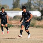 Dynamic shot of young soccer players on a field during a sunny day.