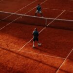 Intense tennis match on a vibrant clay court, capturing the competitive spirit.