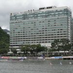 Panoramic view of Regal Riverside Hotel with a dragon boat race on the Shing Mun River in Hong Kong.