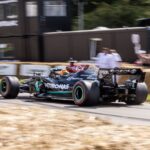 Mercedes Formula One car racing at high speed on an outdoor track in England.