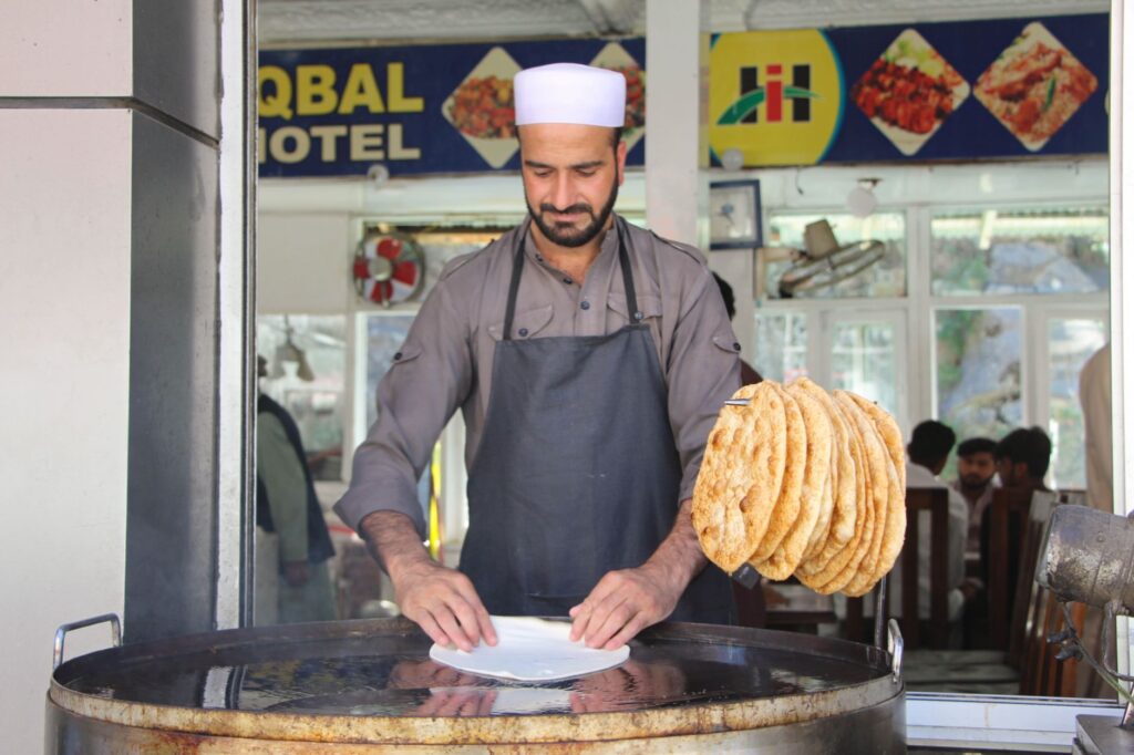 Local chef prepares traditional paratha at a food stall in Bahrain, Pakistan.