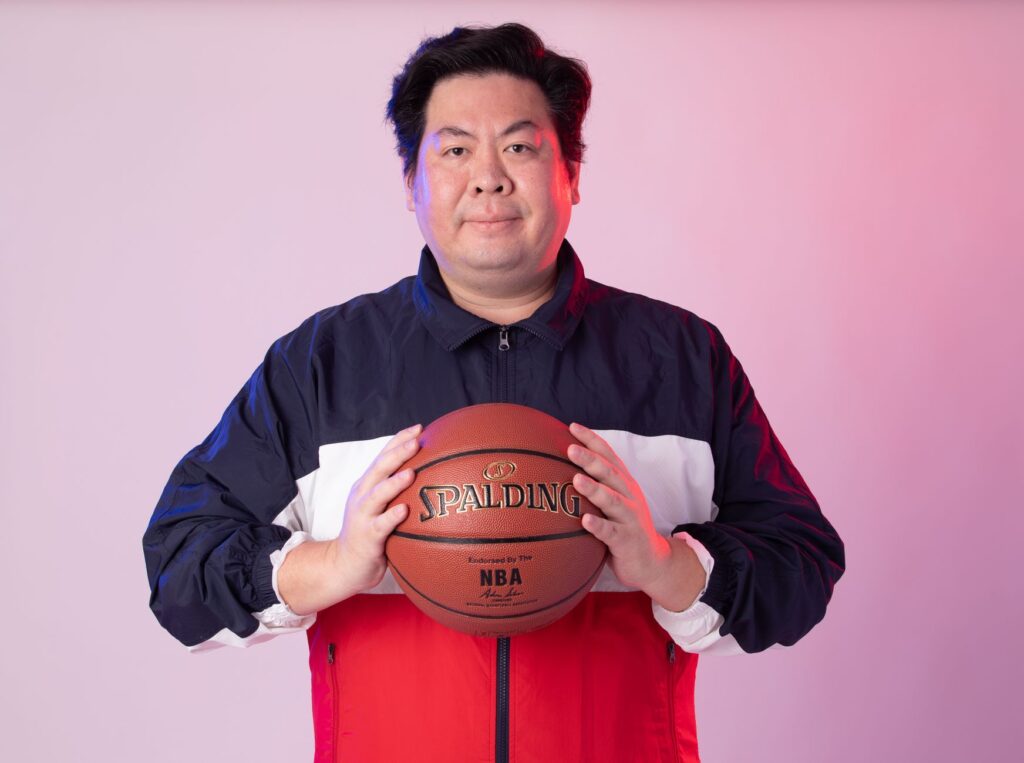 Man in sportswear with basketball against a gradient background.