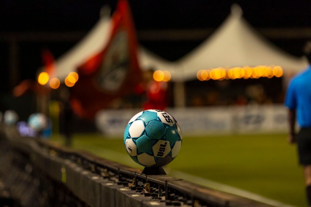 Close-up of a soccer ball on the sidelines at a night stadium event