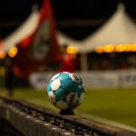 Close-up of a soccer ball on the sidelines at a night stadium event