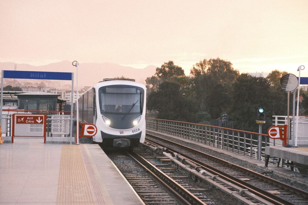 Modern train at Hilal Metro Station, Izmir, during sunset, showcasing public transportation.