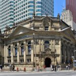 Explore the historic neoclassical facade of the Hockey Hall of Fame in Toronto's bustling cityscape.