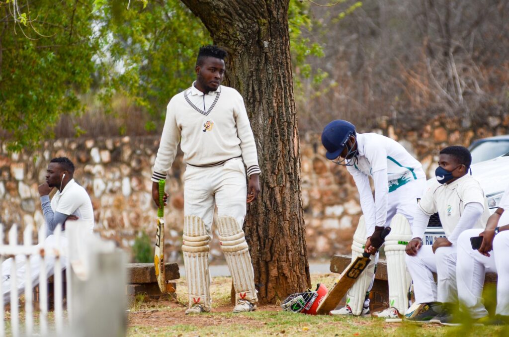 Cricket players in sportswear ready to start a match, showcasing camaraderie and focus in an outdoor setting.
