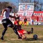 Dynamic soccer match action captured as players compete for the ball in a lively stadium.
