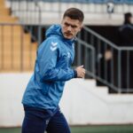 Focused football player warming up on the field in Baku, Azerbaijan, showcasing athletic determination.