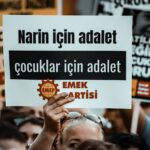 A crowd holds signs advocating for justice and children's rights at a protest.