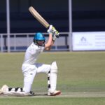 Two young cricketers playing a match, showcasing batting skills on the field.