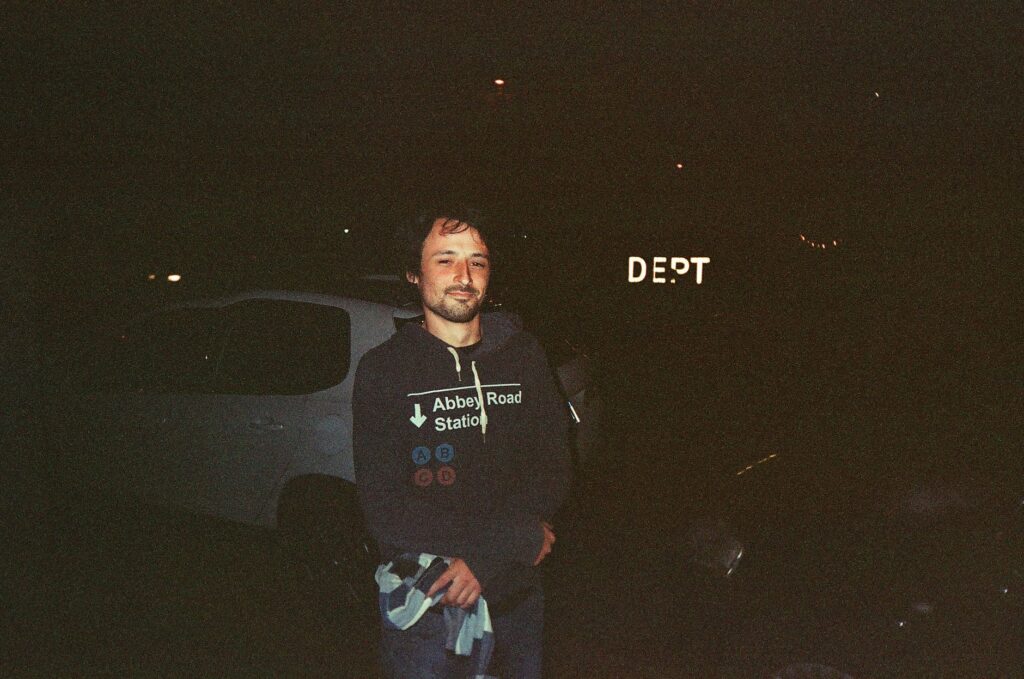 A man in a black hoodie stands outside at night in Mar del Plata, Argentina.