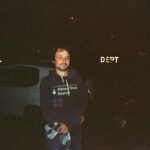 A man in a black hoodie stands outside at night in Mar del Plata, Argentina.