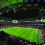 A captivating night football match at a packed stadium in England, showcasing dynamic gameplay and vibrant atmosphere.