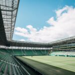 View of a modern stadium in Budapest, Hungary, showcasing green seats and a vast open sky.