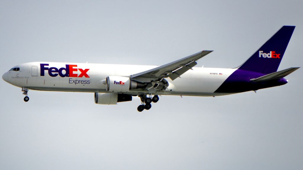 FedEx Boeing aircraft flying against a clear sky, showcasing air freight services.