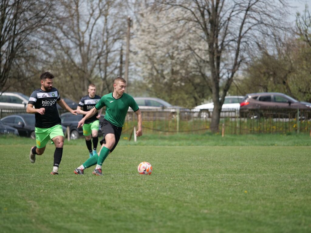 Action shot of an amateur soccer match in a park, showcasing teamwork and skill.