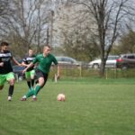 Action shot of an amateur soccer match in a park, showcasing teamwork and skill.