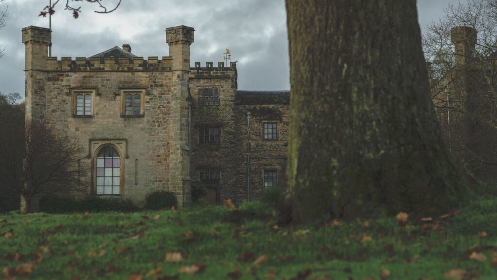 Towneley Hall in Lancashire, surrounded by lush greenery and a moody sky.