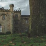 Towneley Hall in Lancashire, surrounded by lush greenery and a moody sky.