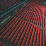 Rows of empty red seats in a UEFA Europa League stadium, captured from above.