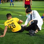 Soccer player receiving medical aid on the field for injury during a match.